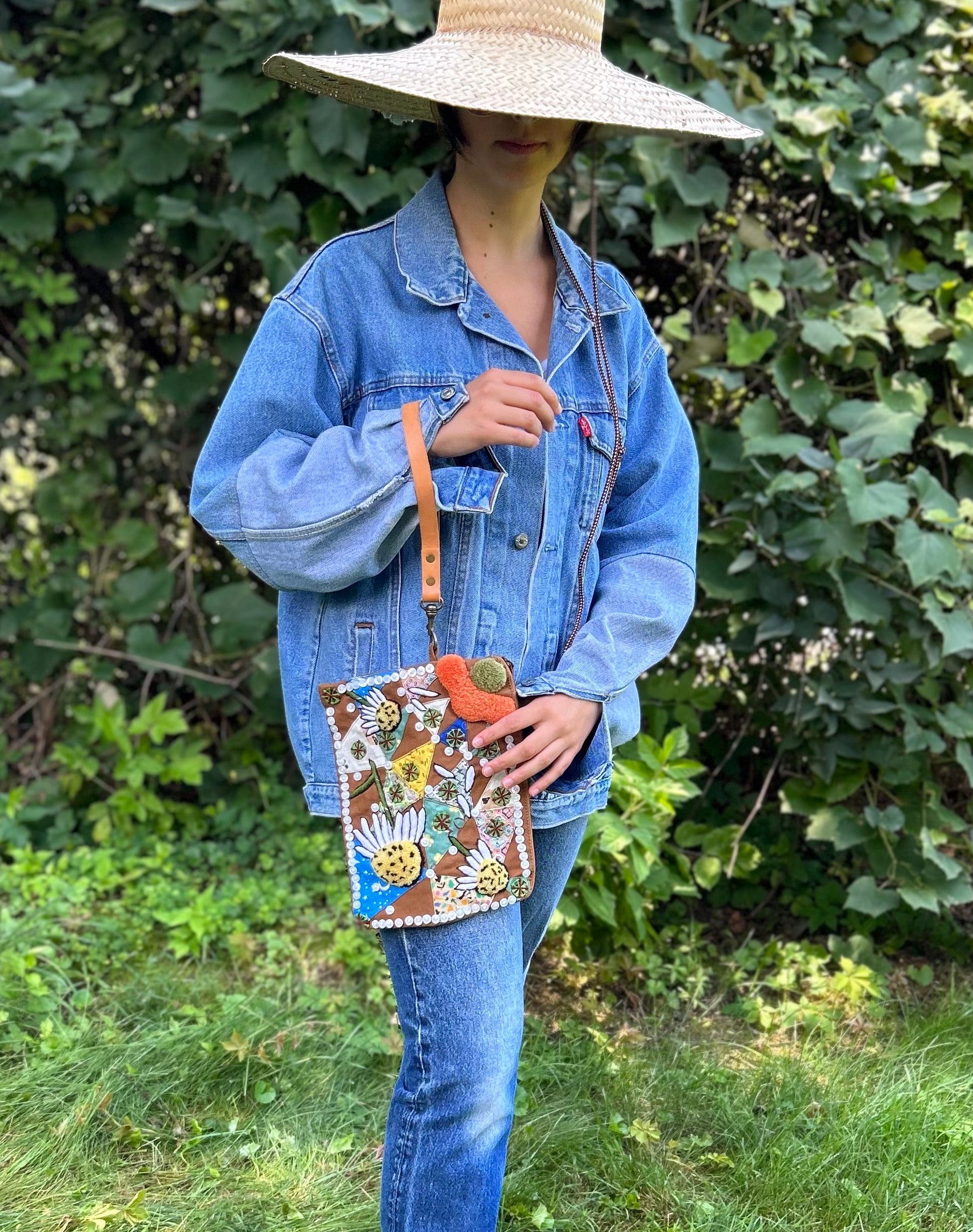 Pouch with embroidered and button embellishments, front view