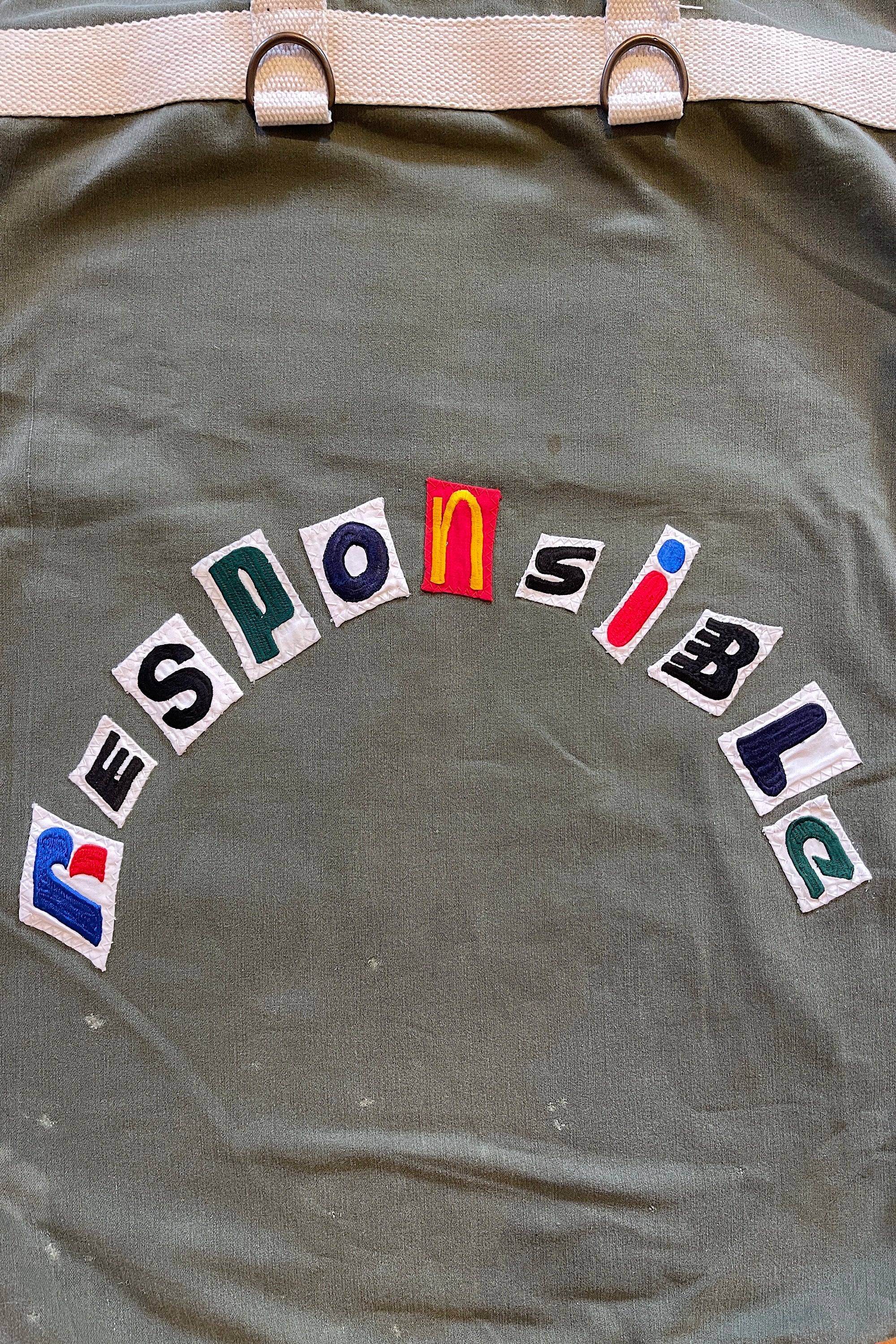 Upcycled army laundry bag with “responsible” text, close up view 