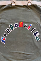 Upcycled army laundry bag with “responsible” text, close up view 
