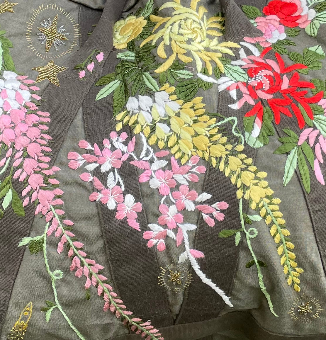 Upcycled aviator bag with embroidered embellishments, close up view 