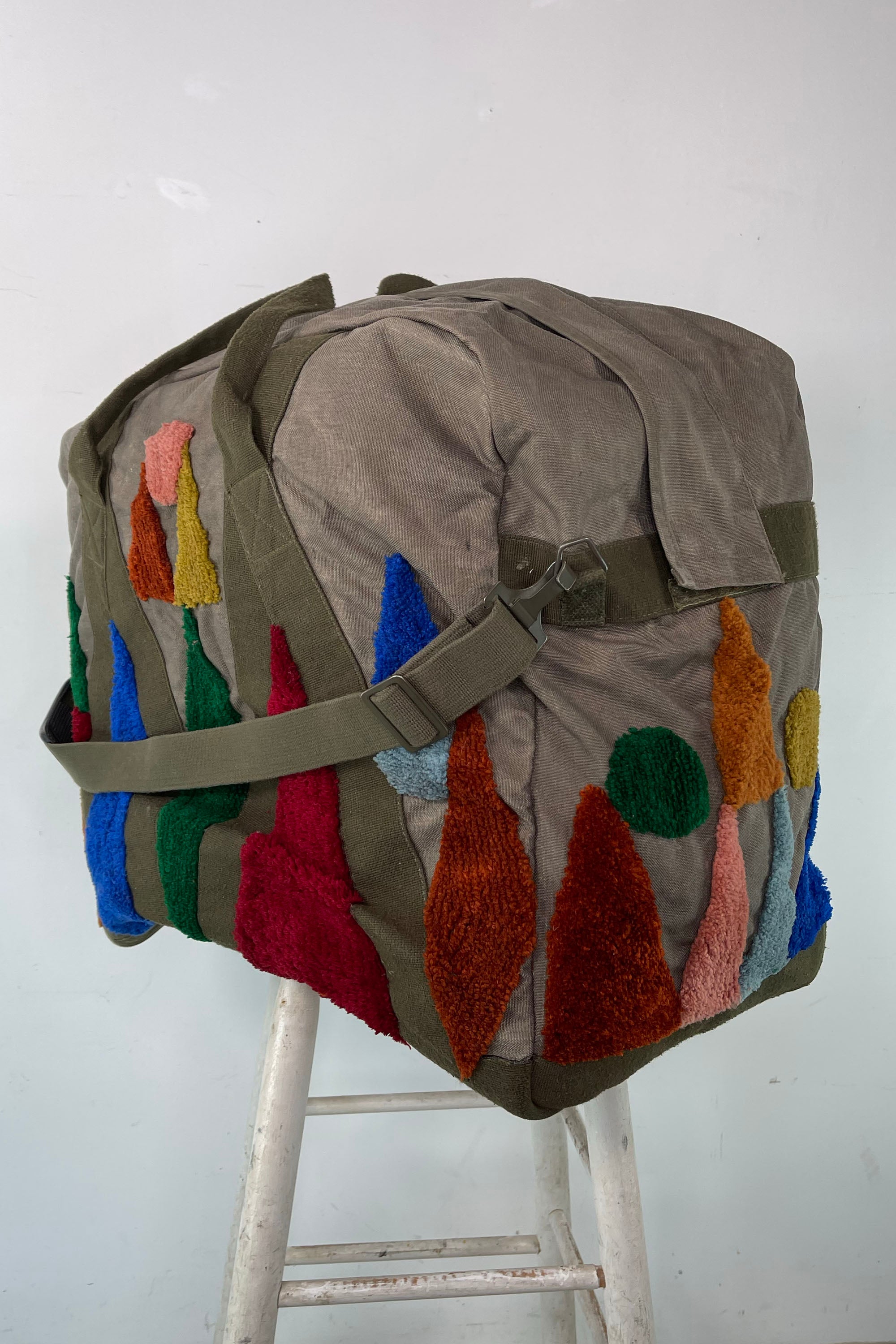 Upcycled aviator bag with tufted embellishments, side view 