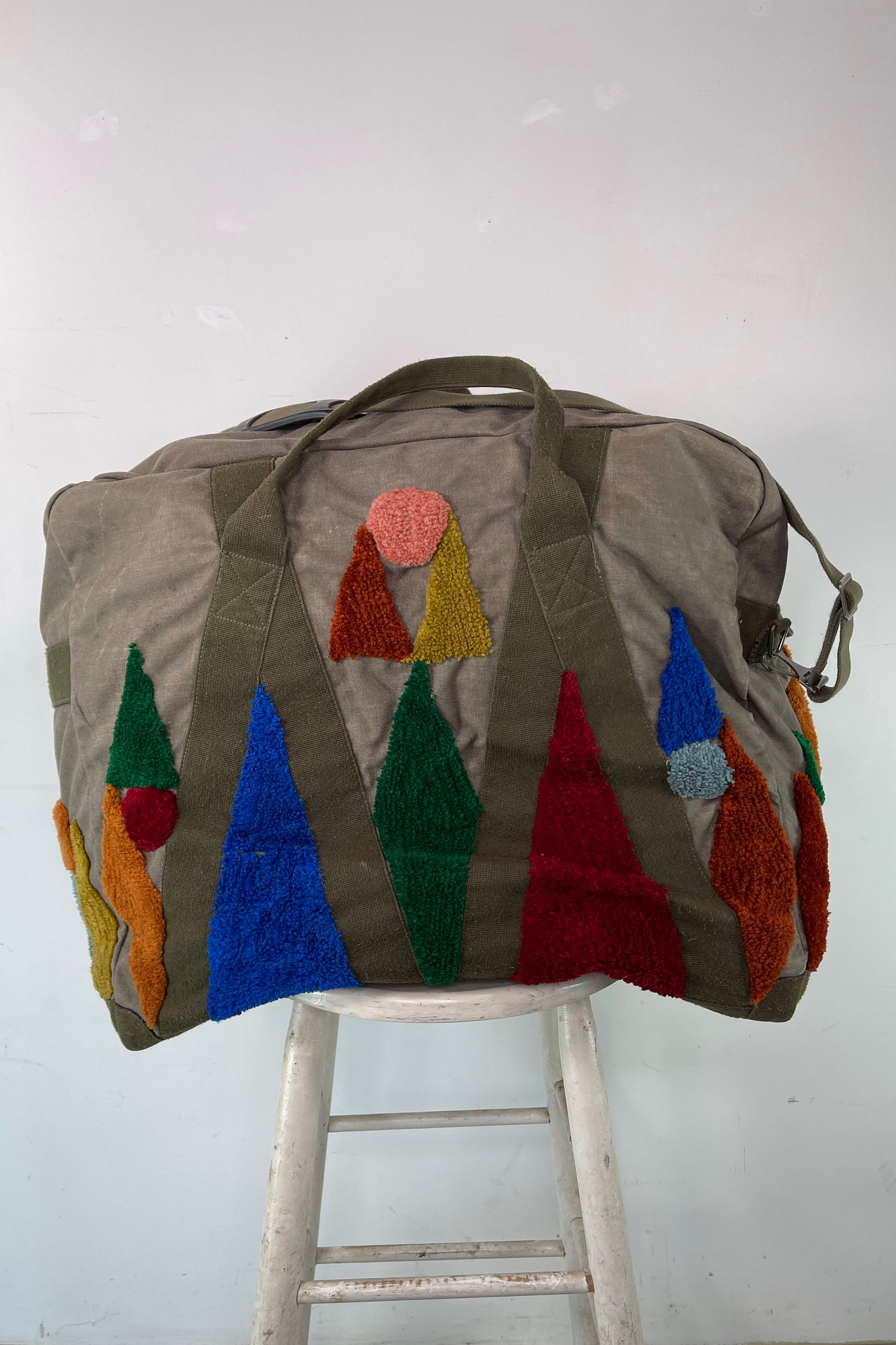 Upcycled aviator bag with tufted embellishments, front view 