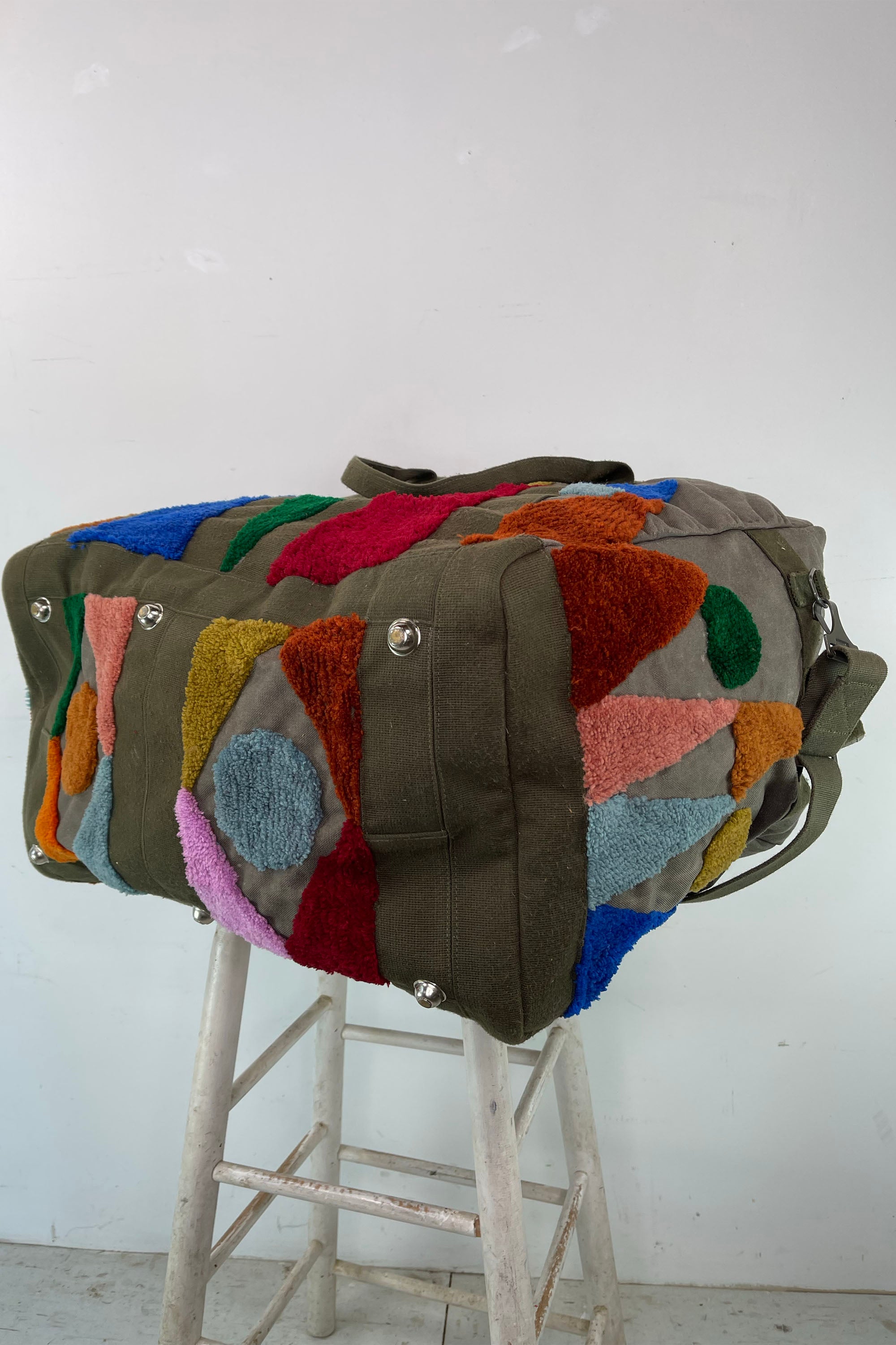 Upcycled aviator bag with tufted embellishments, bottom view 
