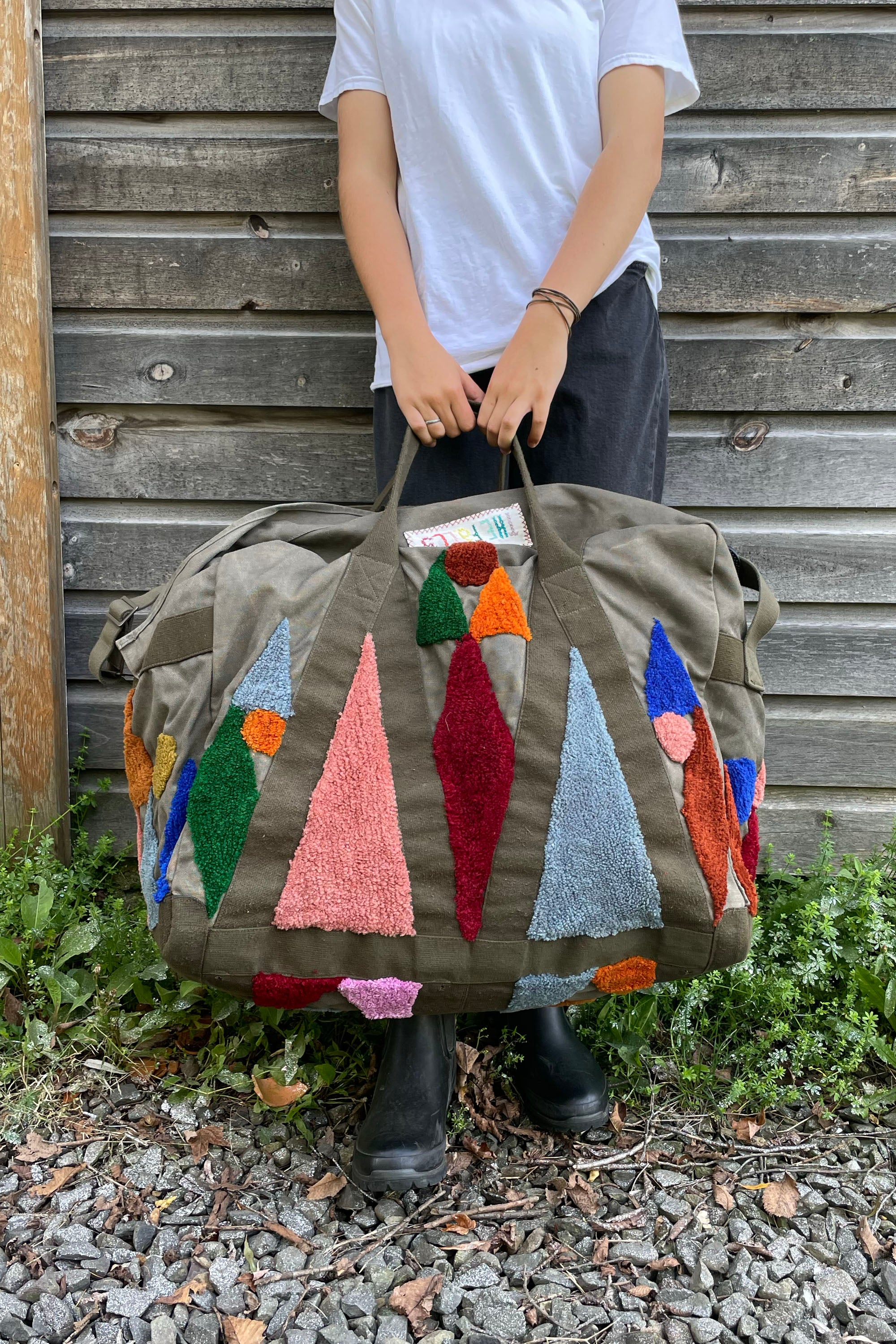 Upcycled aviator bag with tufted embellishments, front view 