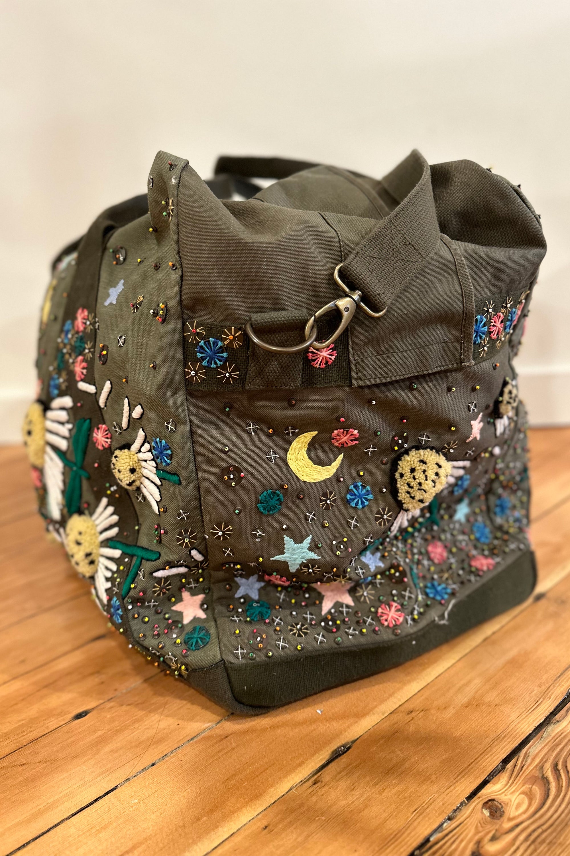 Upcycled aviator bag with embroidered embellishments, side view 