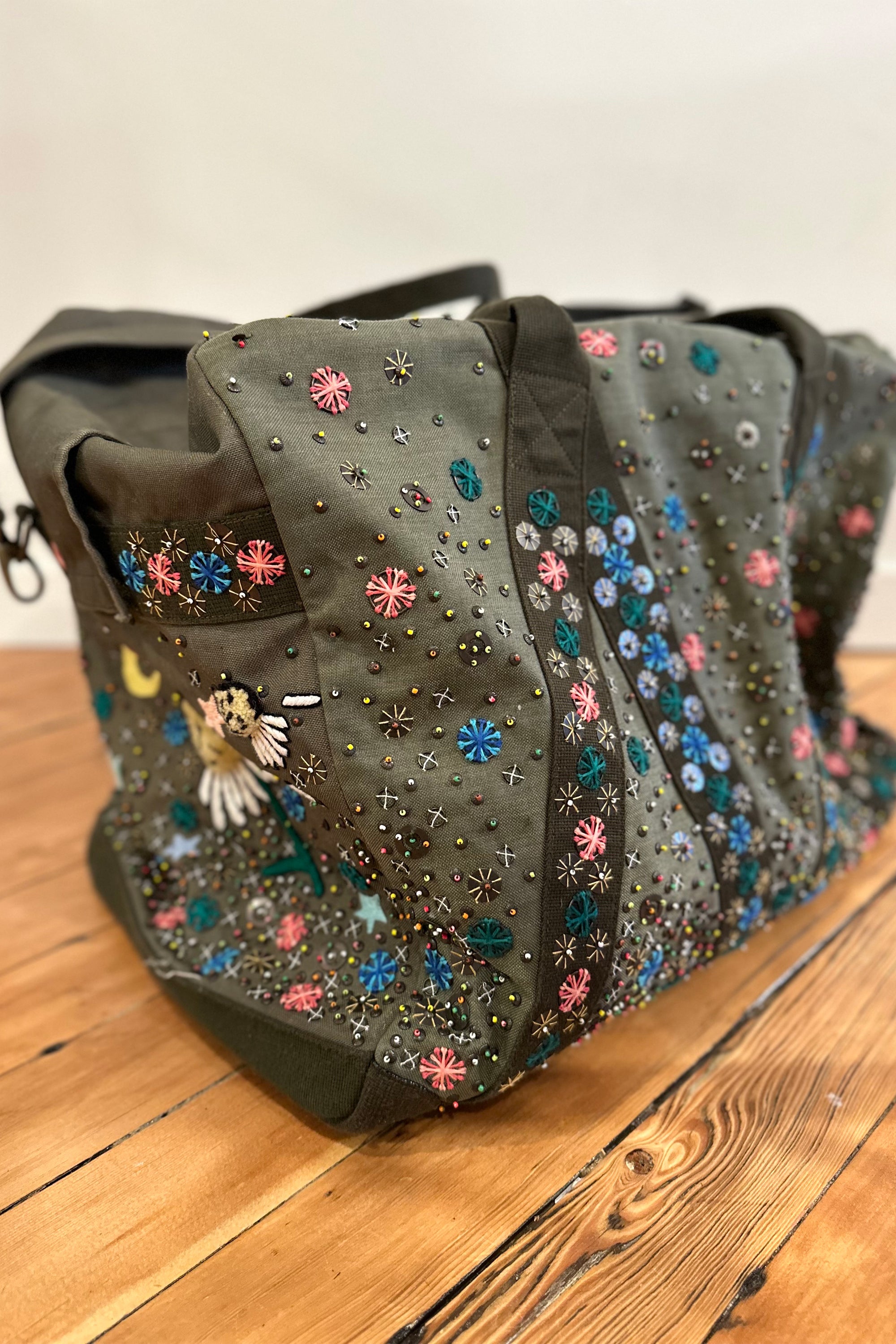Upcycled aviator bag with embroidered embellishments, side view 