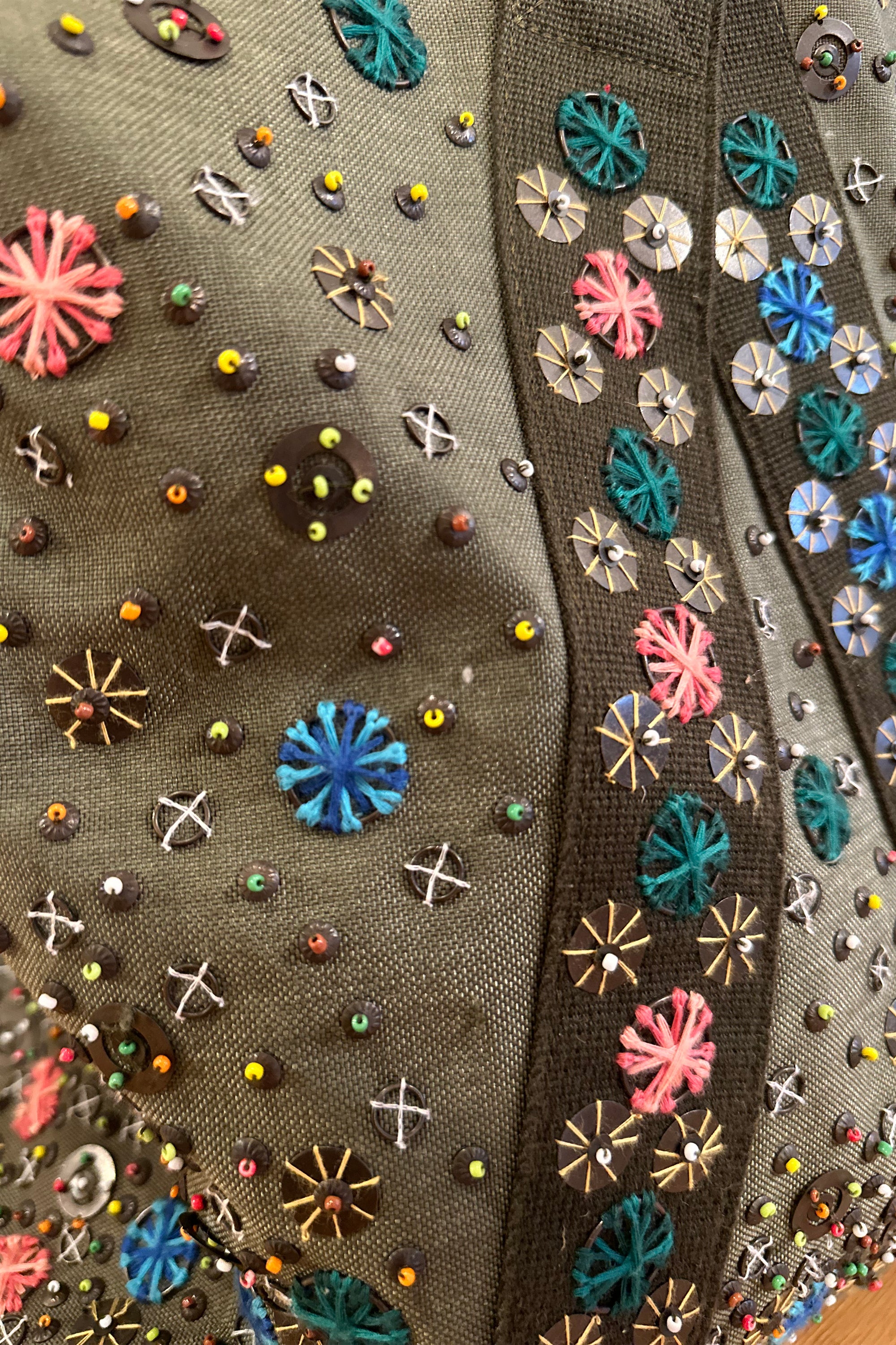 Upcycled aviator bag with embroidered embellishments, close up view 